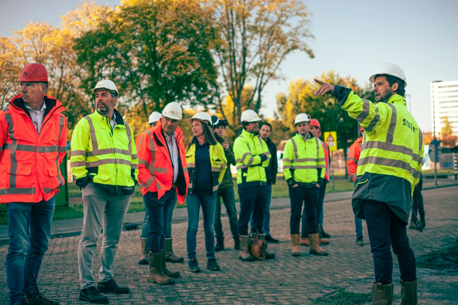 Overleg op de bouwplaats met medewerkers in veiligheidskleding