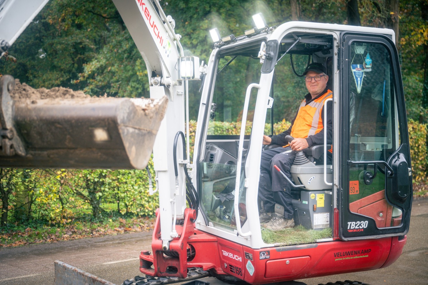 Minigraver aan het werk in een woonstraat